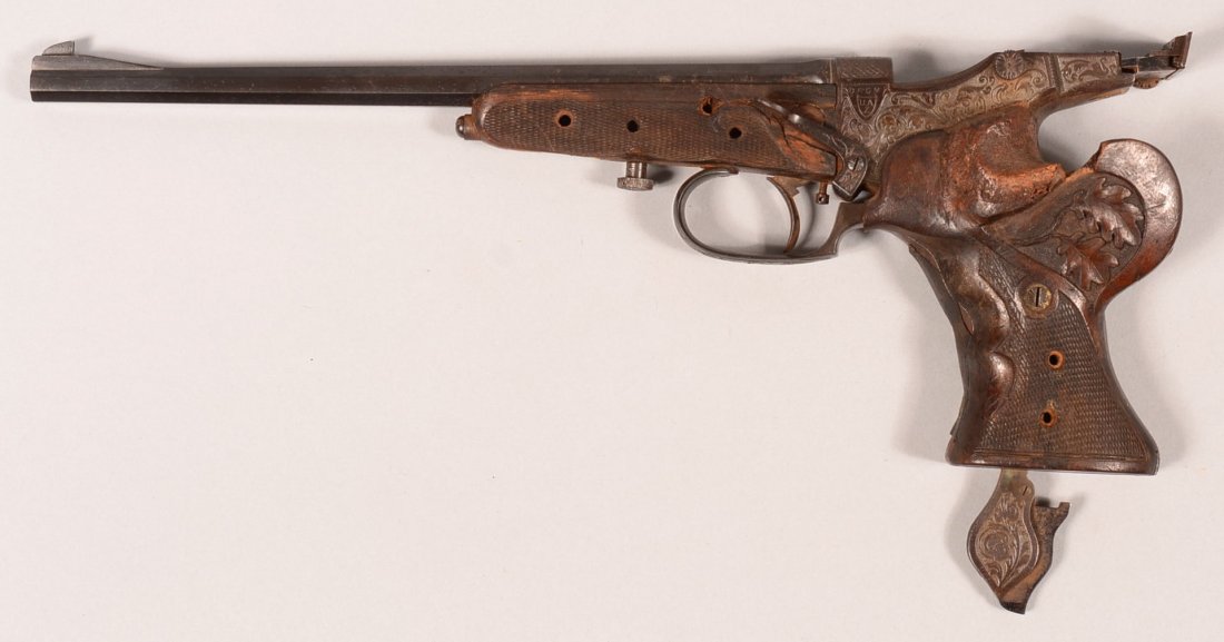 CR. Engraved Udo Anschutz model 210 single shot target: CR. Engraved Udo Anschutz model 210 single shot target pistol having a 22 caliber 11" octagon barrel, serial number 6844 with set trigger, checkered forearm and carved oak leaf pattern in left grip. C