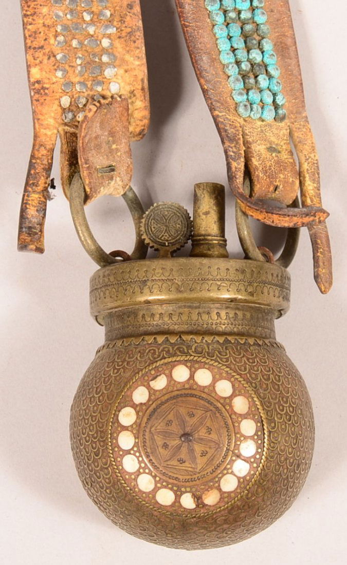 19th century Berber mother-of-pearl decorated brass: 19th century Berber mother-of-pearl decorated brass powder flask with leather shoulder strap covered with brass head tacks. 3-3/4" body. Condition: good