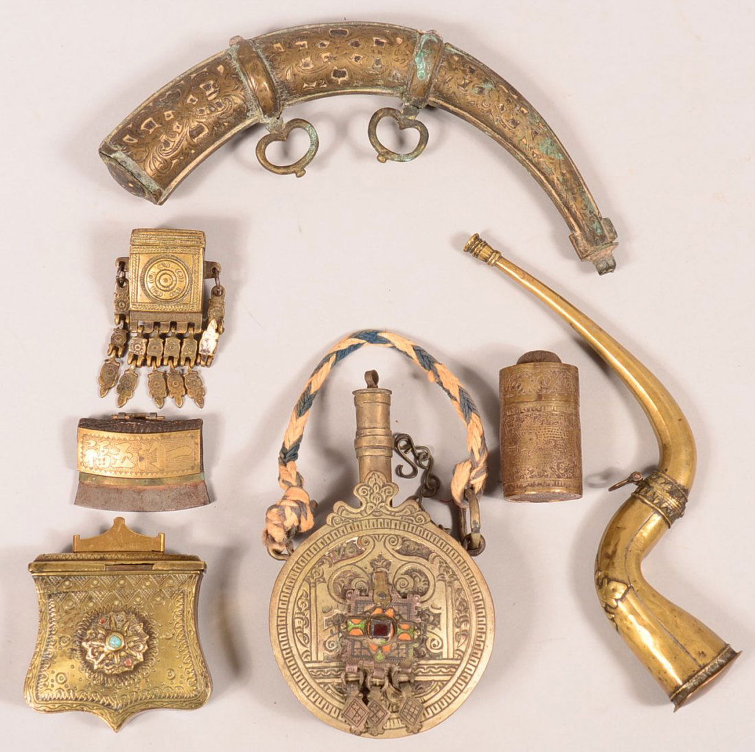 Lot of assorted decorated Arabian and central Asian: Lot of assorted decorated Arabian and central Asian brass powder flasks and accoutrement boxes including a "chuckmuk" fire steel. Condition: good to very good.