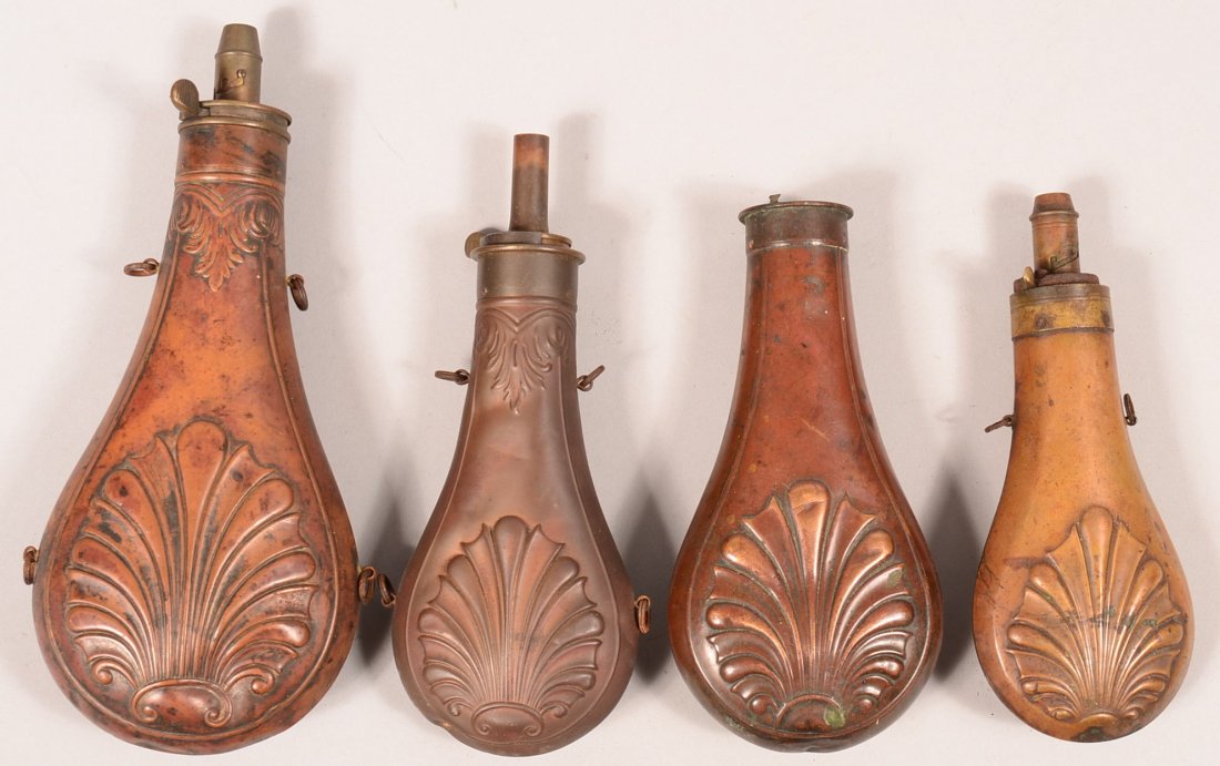 Lot of (4) shell design brass powder flasks, 6" to: Lot of (4) shell design brass powder flasks, 6" to 8-1/2" bodies. (2) are marked AM. FLASK & CAP CO on top. Condition: one is missing the charger, otherwise good.