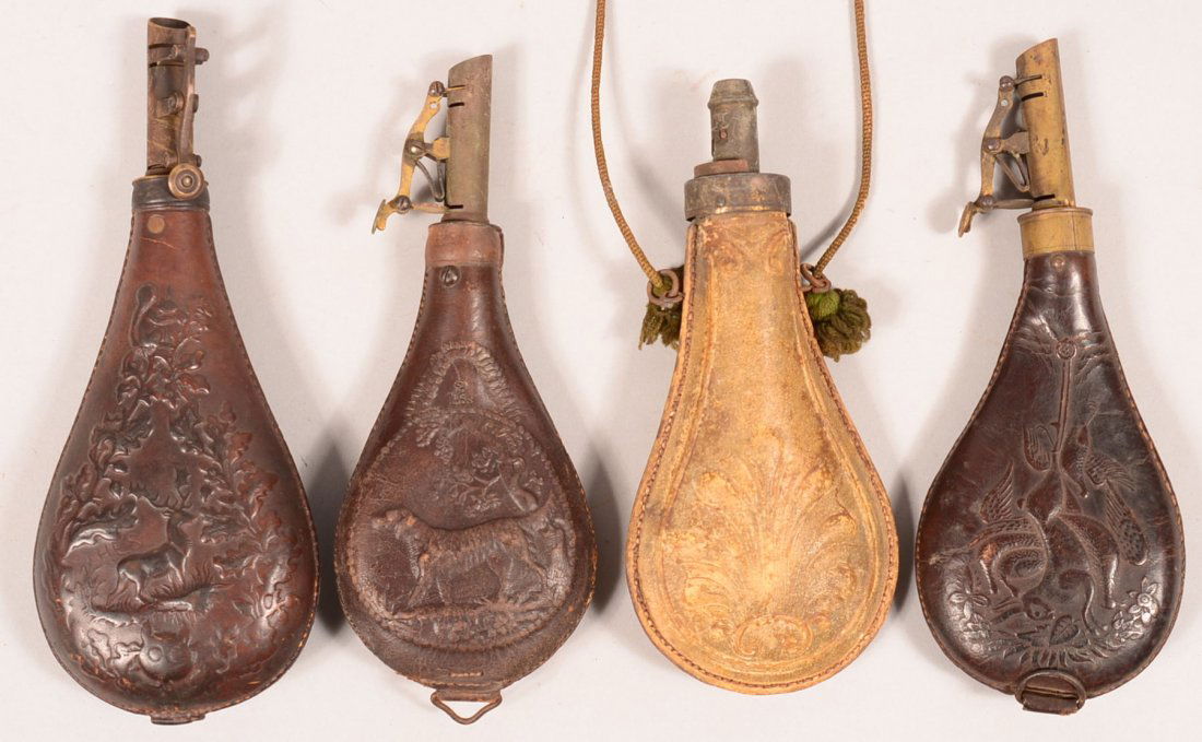 Lot of (4) leather shot pouches having brass chargers: Lot of (4) leather shot pouches having brass chargers and raised designs: stag, dog, buff color shell, and hanging game. 6" to 6-3/4" bodies. Condition: good to very good.