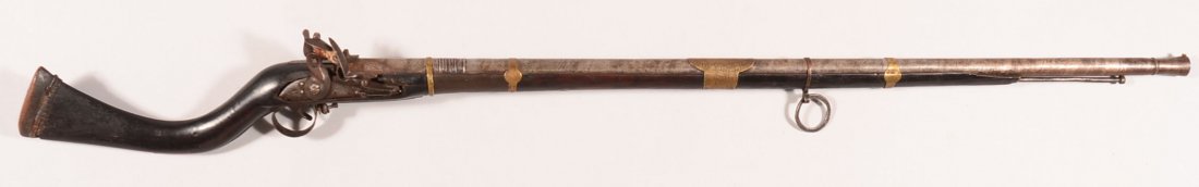 Jezail flintlock musket having a 39" round barrel with: Jezail flintlock musket having a 39" round barrel with a flared muzzle, (4) brass barrel bands, iron ramrod, and chiseled designs in the iron pieces. 53-1/2" o/a. Condition: good with some small wood