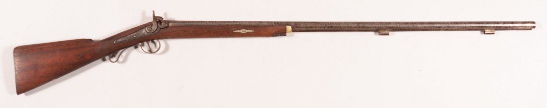 Percussion fowler having a 12 gauge 40" octagon to: Percussion fowler having a 12 gauge 40" octagon to round damascus barrel, german silver wedge escutcheons, and a german silver cap trap in the botton of the buttstock. Condition: good with vivid twist