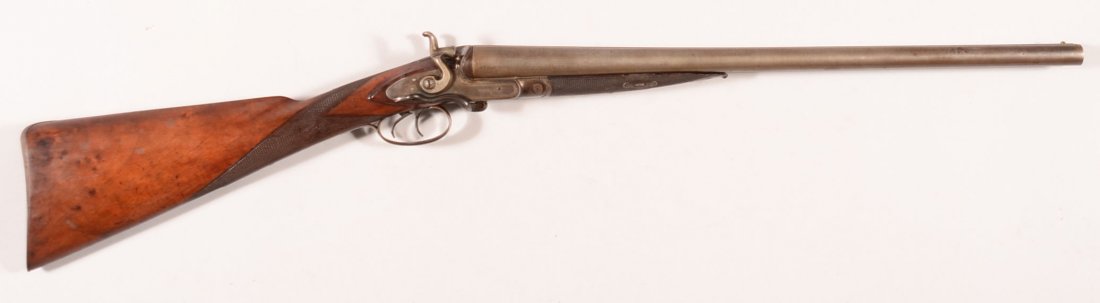 Dean side lever double barrel SxS hammer shotgun having: Dean side lever double barrel SxS hammer shotgun having British proofs and 12 gauge damascus barrels shortened to 22", sn 1002 with a checkered straight grip. Condition: steel gray barrels, traces of 