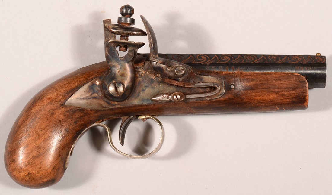 Spanish made modern flintlock derringer pistol having a: Spanish made modern flintlock derringer pistol having a 44 caliber 4" engraved barrel, sn25811. Condition: good with a sticky action.