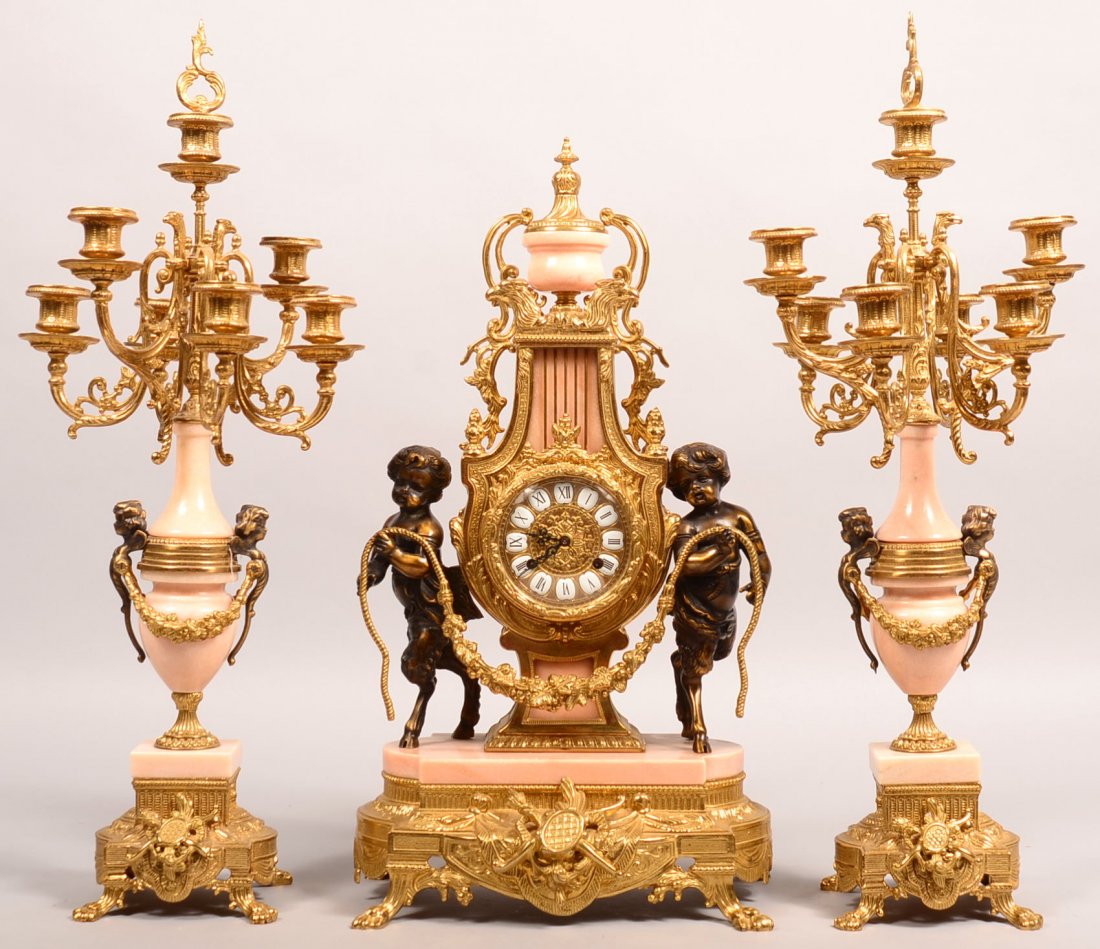 20th Century Franz Hermle Mantle Clock Set. Mix-metal,: 20th Century Franz Hermle Mantle Clock Set. Mix-metal, Clock with eagle head and urn top, pan figures holding swag garland, base with plaque and paw feet, two candelabras with seven candle light. Cloc