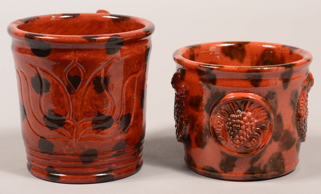 Two James Seagreaves Sponge Glazed Pottery Mugs. Both: Two James Seagreaves Sponge Glazed Pottery Mugs. Both signed on base "JCS". One has embossed bird and cluster of grape medallions, 3-1/2"h. and one has sgrafitto tulip and "1976" design, 4-3/8"h. Cond