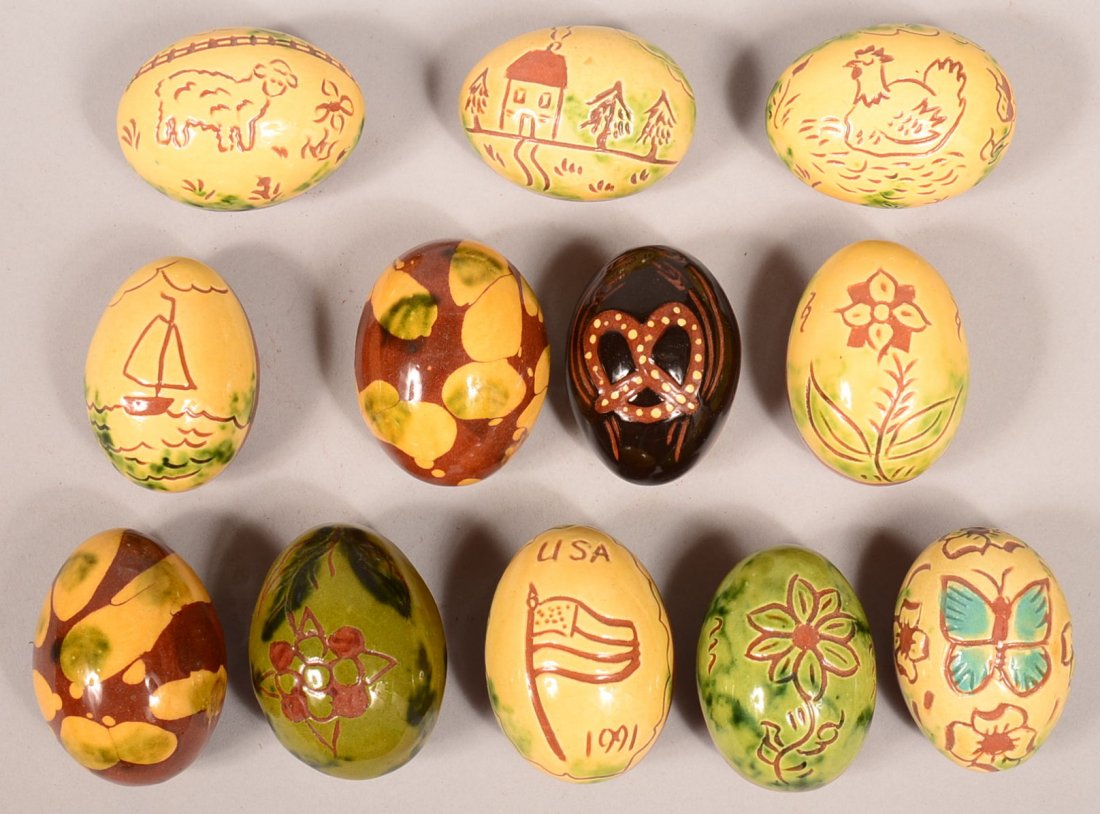 Lot of 12 Breininger Redware Pottery eggs. Having: Lot of 12 Breininger Redware Pottery eggs. Having various glazed and/or sgrafitto decoration. 2-1/4" to 2-1/2"l. Condition: Very good.