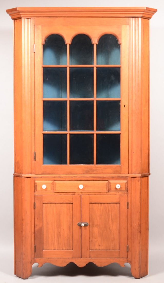 Pennsylvania 19th Century Softwood Two Part Corner: Pennsylvania 19th Century Softwood Two Part Corner Cupboard. Molded cornice with 12 pane glazed arched top upper door, dovetailed drawer flanked by false drawers, two lower sunken panel doors, ogee mo