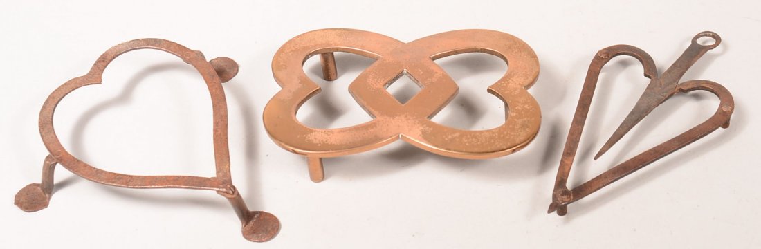 Three Heart Shape Trivets. Two wrought iron with: Three Heart Shape Trivets. Two wrought iron with riveted feet and one brass double heart style, 1/2"-1-1/2"h. x 7-14"-8-1/4"l. Condition: Good with use wear.