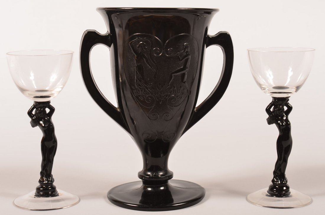 L.E. Smith Dancing Nymph Black Amethyst Trophy Cup: L.E. Smith Dancing Nymph Black Amethyst Trophy Cup Vase, Circa. 1930's. 8-1/4" high. Plus a pair of Cambridge Nude Figural Ebony Cocktail Stemware Glasses. This "statuesque" cocktail glass with a nude