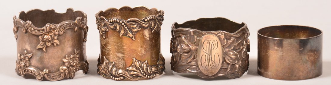 Four Sterling Silver Napkin Rings. Three are American: Four Sterling Silver Napkin Rings. Three are American with floral and foliate embossing, one is English with no decoration. 1-1/8" to 1-3/8" high. 5.60 troy ozs. Condition: Very good with minor wear.