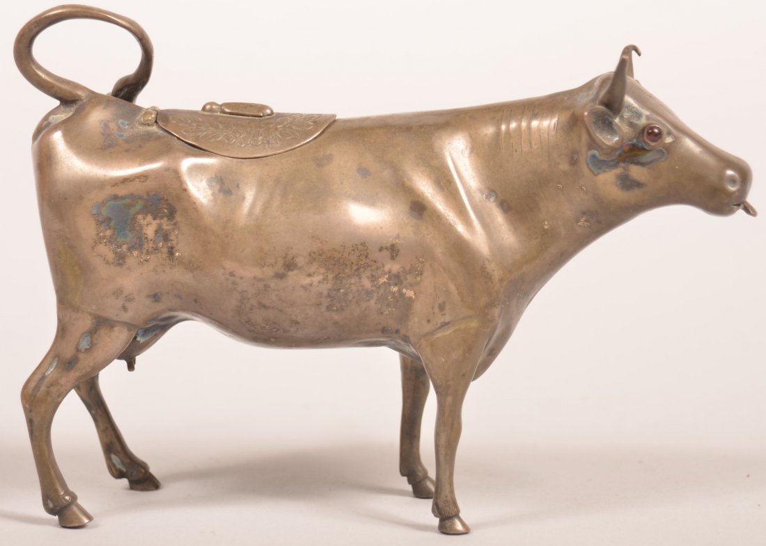 Early 20th Century Scottish .833 Silver Cow Creamer.: Early 20th Century Scottish .833 Silver Cow Creamer. Date mark for 1910-1911. Hinged lid on back and ruby glass eyes. 6-1/2" long. 7.52 troy ozs. Condition: Very good with some wear.