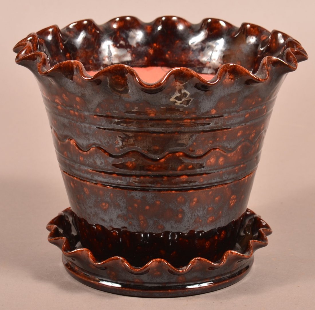 Breininger Redware Pottery Flower Pot with attached: Breininger Redware Pottery Flower Pot with attached saucer base. Mottled glaze and fluted edges, 7-1/2"h. x 9"dia. Condition: Very good.