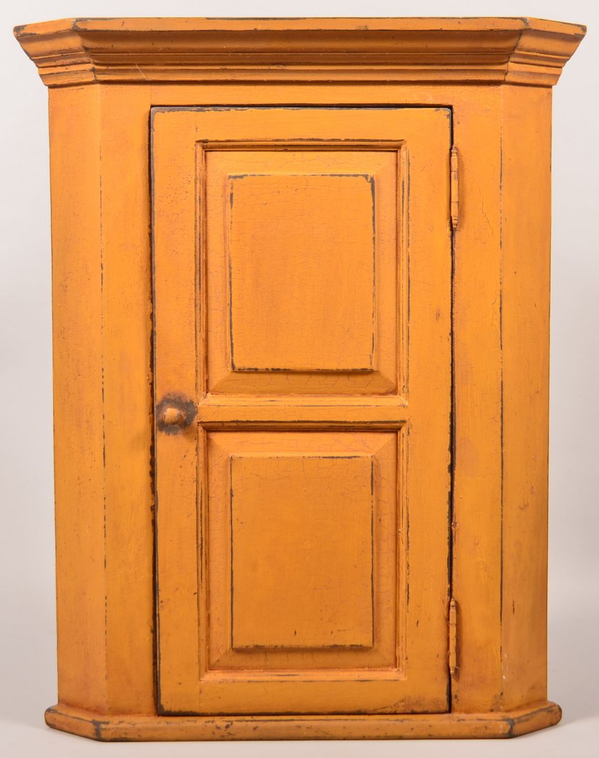 Painted Hanging Corner Cupboard by Luigi Rossi. Painted: Painted Hanging Corner Cupboard by Luigi Rossi. Painted mustard yellow, molded cornice, double panel door with interior shelves, signed on top Luigi Rossi Pennsylvania Folk, 31-1/4"h. x 25"w. x 12-1/4