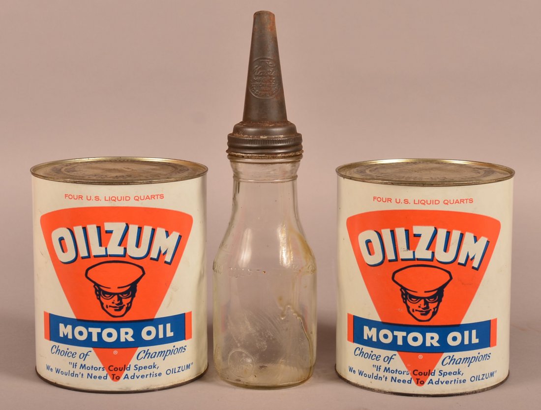 Three Motor Oil Advertising Pieces. Glass oil one quart: Three Motor Oil Advertising Pieces. Glass oil one quart bottle with tin cone cap marked The Master, 14"h, and Two full four gallon Oilzum Cans. 7-3/4"h. Condition: Good.