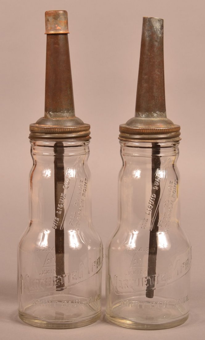 Two Marquette Mfg. Company Glass Oil Bottles with Cone: Two Marquette Mfg. Company Glass Oil Bottles with Cone shaped metal spouts. Embossed lettering one quart bottle Marquette Mfg. Co. Saint Paul, Minn. 14"h. Condition: Very good.