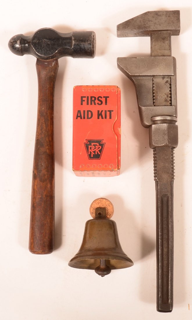 Four Railroad Items. Plumb Leader stamped Pennsylvania: Four Railroad Items. Plumb Leader stamped Pennsylvania Railroad, Pennsylvania First Aid Kit, Adjustable Wrench marked LVRR, unmarked brass bell, Condition: Good.