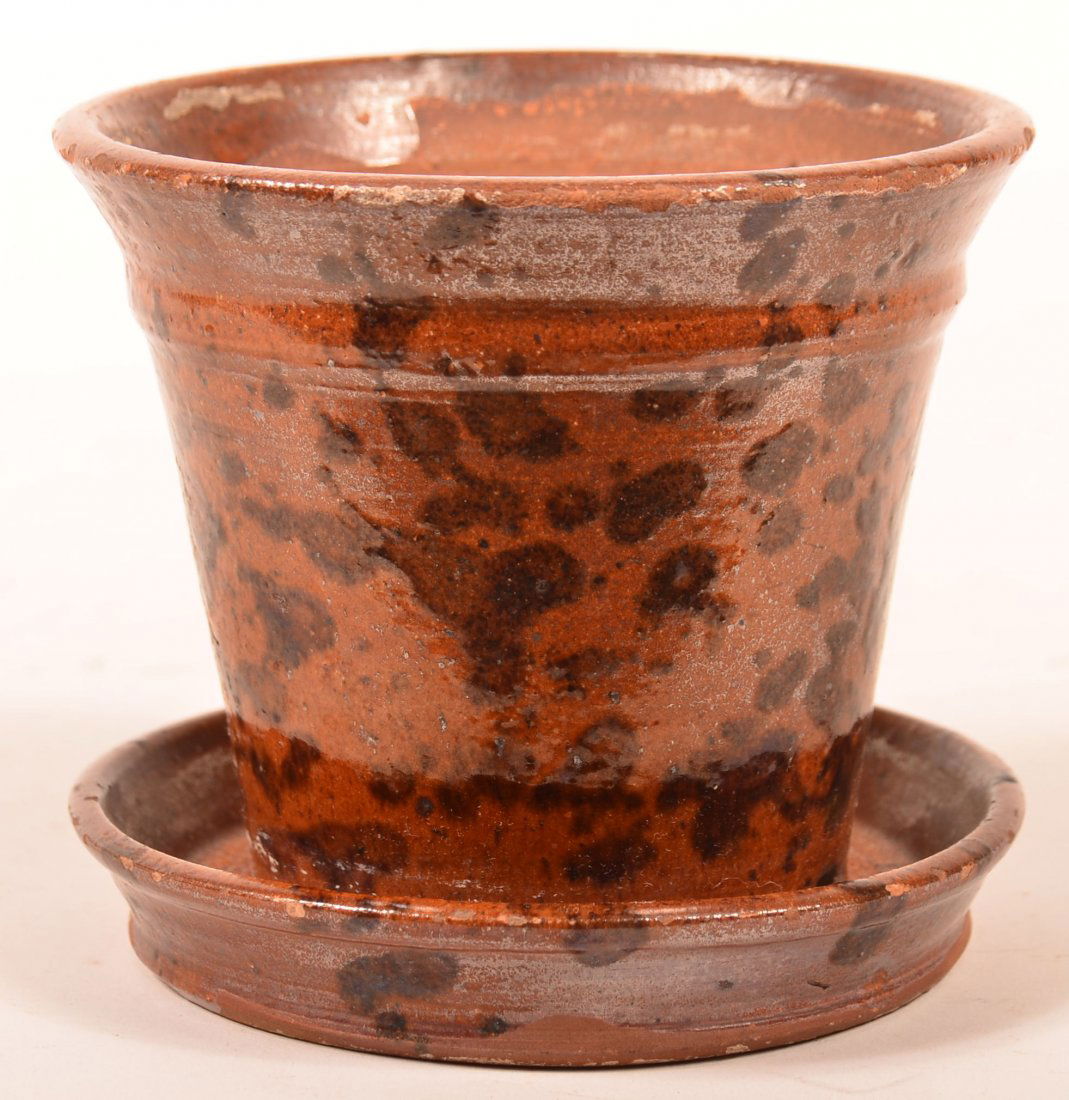 19th Century Redware Pottery Planter with saucer base.: 19th Century Redware Pottery Planter with saucer base. Tapered body with mottled glaze. 5" high. Condition: Good with glazing wear on edges.