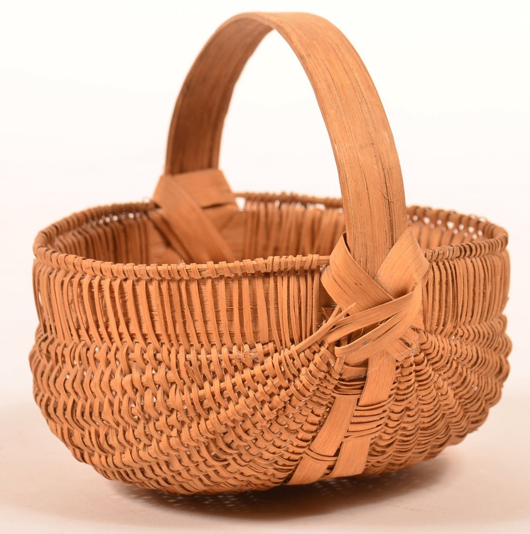 Woven Splint White Oak Egg Basket. Round form with: Woven Splint White Oak Egg Basket. Round form with ribbed construction and bent wood handle with braided re-enforcement. Nice honey patina. 5"h x 6"w. Condition: Good with minor losses.