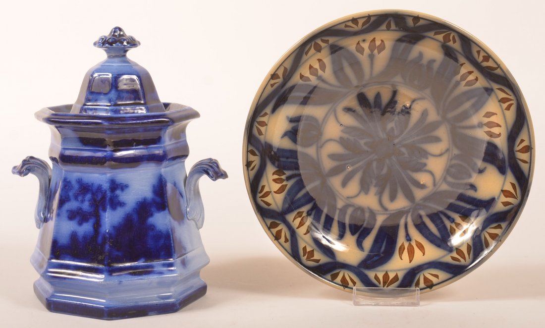 Two Pieces of Flow Blue Decorated China. 1st: "Chapoo": Two Pieces of Flow Blue Decorated China. 1st: "Chapoo" pattern covered sugar bowl, 8-1/4"h. 2nd: Brush decorated low bowl or mush cup saucer, 8-5/8" diam. Condition: Sugar bowl has rim chips.