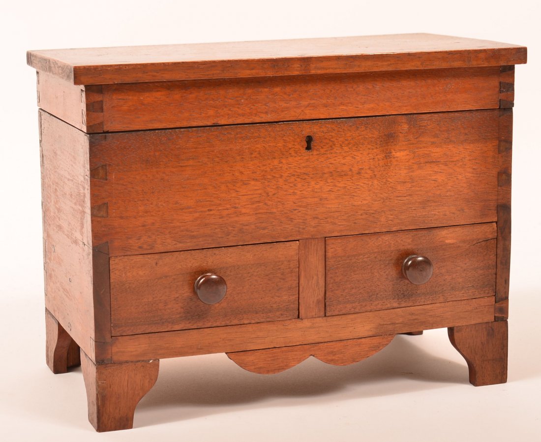 19th Century Walnut Miniature Chest. Single board: 19th Century Walnut Miniature Chest. Single board hinged top, dovetailed case, two split lower dovetailed drawers, applied skirt and shaped bracket feet. 9-7/8"h. x 12-7/8"w. x 6-5/8"d. Condition: Ver