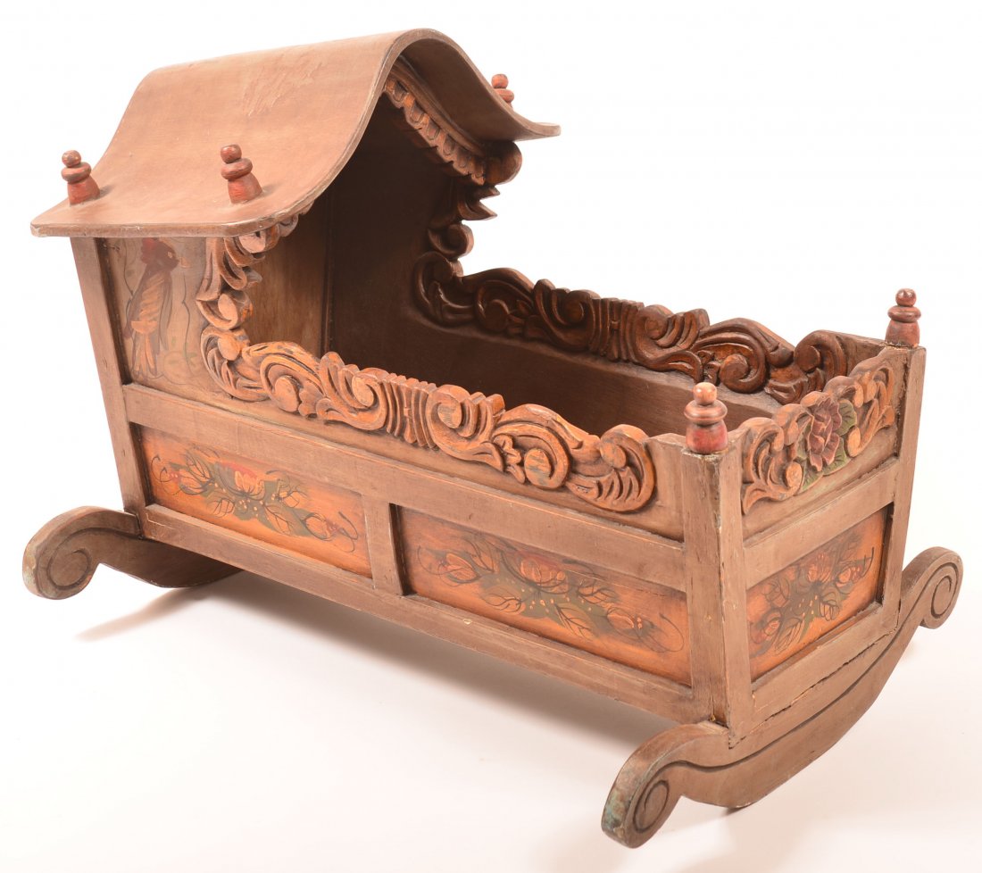Continental Carved and Molded Paint Decorated Doll: Continental Carved and Molded Paint Decorated Doll Cradle. Hooded form with carved trim, turned finials, paneled sides and cheese-cutter rockers. Polychrome paint decorated with bird, floral and folia
