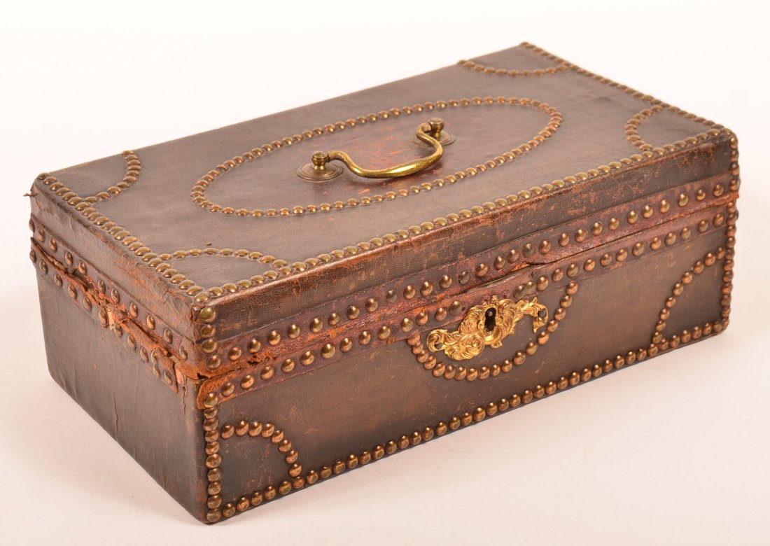 19th Century Leather Covered and tack decorated: 19th Century Leather Covered and tack decorated Document Box. Wallpaper lined with spurious label added. 4-1/4"h. x 12"w. x 7"d. Condition: Good with minor losses and wear.