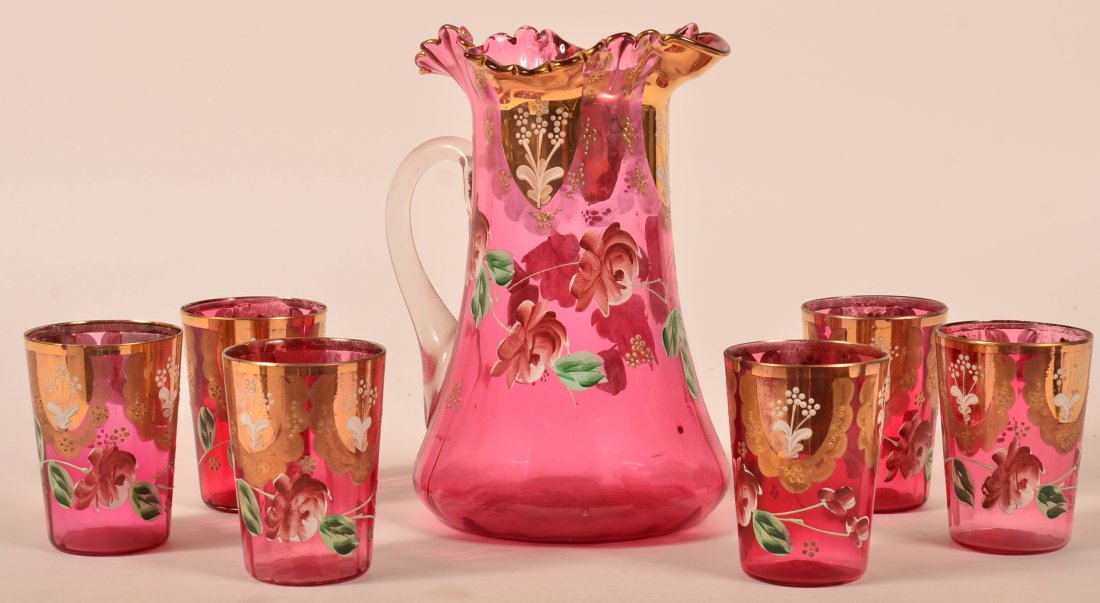 Cranberry Victorian Art Glass Water Set with Rose and: Cranberry Victorian Art Glass Water Set with Rose and Floral Heavy Enamel Hand Painted Decoration. Fluted top pitcher with applied clear handle, 9-1/2"h. 6 matching tumblers, 4"h. Condition: Good, one