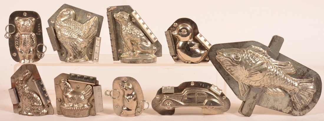 Nine Vintage Figural Chocolate Molds. Including eight: Nine Vintage Figural Chocolate Molds. Including eight animals, fish, turkey, teddy bear, rabbit, duck, hen on nest, seated dog, pig and one automobile, turkey marked made in Berlin Germany, 2-3/4"h. -
