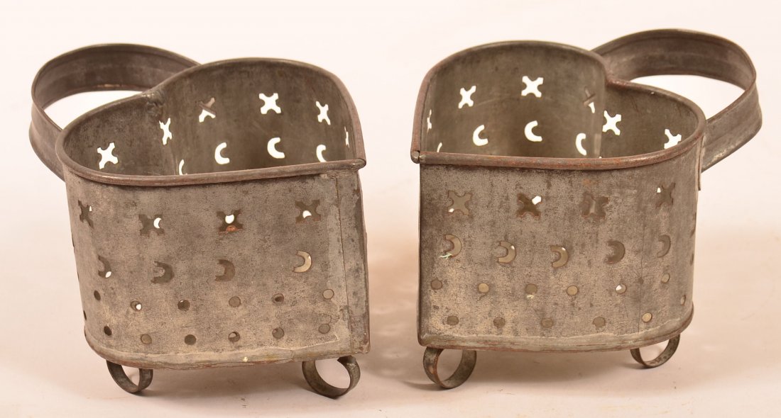 Pair of Pierced Tin Heart Shaped Cheese Molds. Cross,: Pair of Pierced Tin Heart Shaped Cheese Molds. Cross, crescent and circular pierced sides, applied loop handles and ring feet. 4" high. Condition: Very good with minor wear, one foot has a separation.