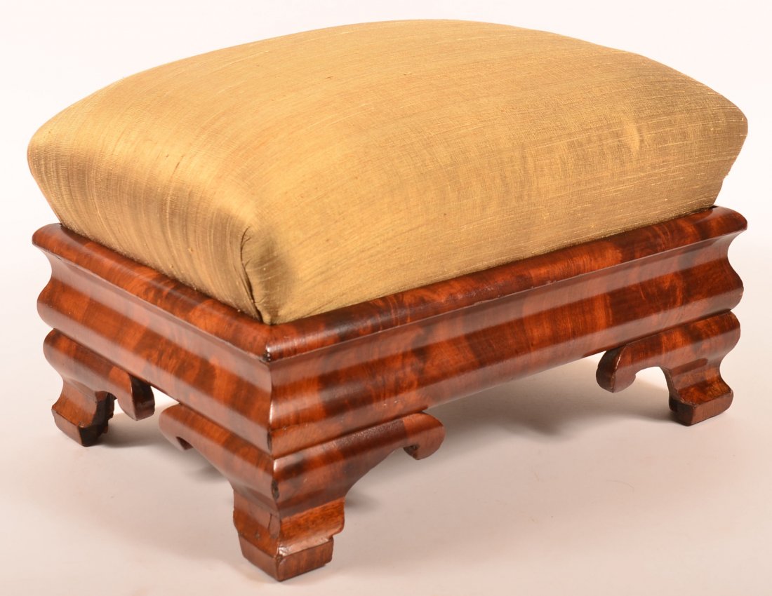 Empire Burl Mahogany Veneered Foot Stool with: Empire Burl Mahogany Veneered Foot Stool with Upholstered Slip Seat. Ogee frame and ogee feet with scrolled spurs. 14"h. x 21"w. x 15"d. Condition: Good with some restoration and losses.