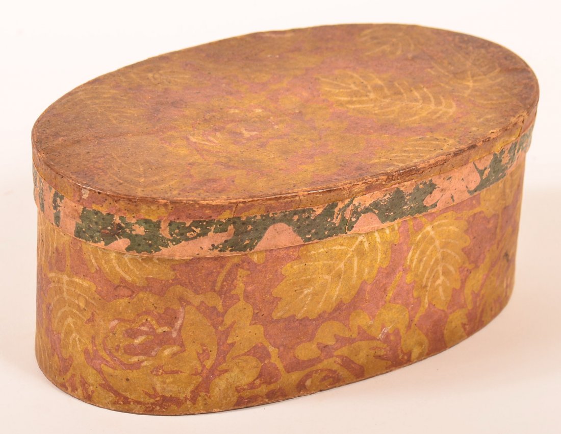Early 19th Century Wallpaper Covered Oval Trinket Box.: Early 19th Century Wallpaper Covered Oval Trinket Box. Mulberry ground with yellow rose and leaf design, applied green band on lid. 3-1/2"h. x 7-3/4"w. 4-1/2"d. Condition: Good with wear.