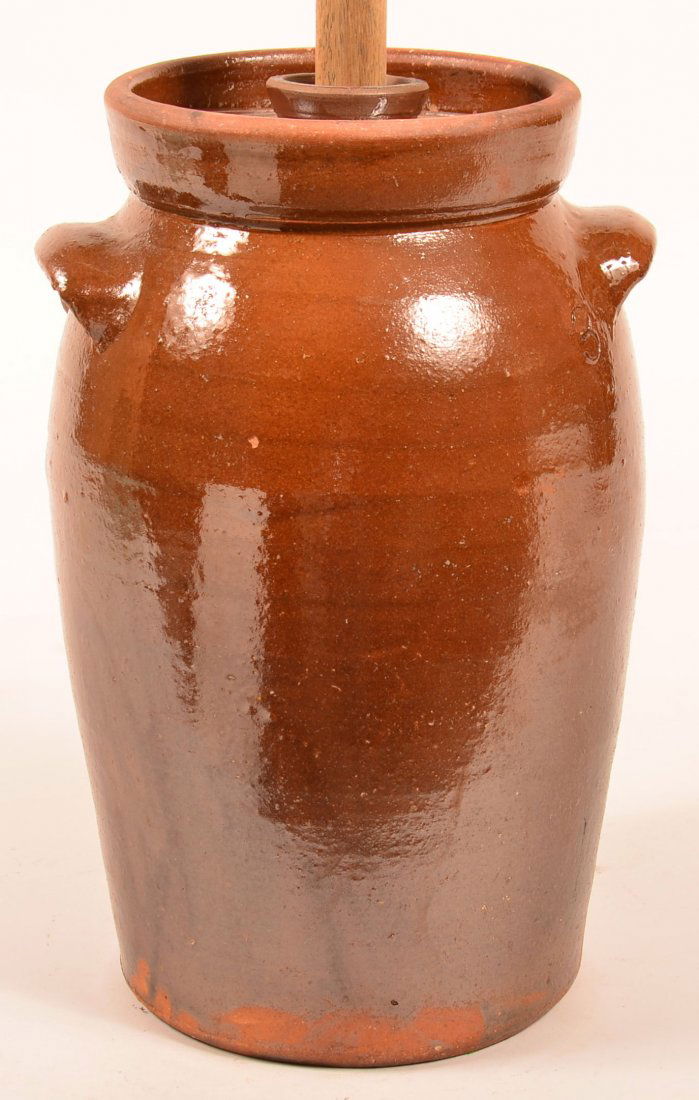 19th Century Glazed Redware Pottery Butter Churn.: 19th Century Glazed Redware Pottery Butter Churn. Bulbous form with ear handles, flared rim, and original lid. With wood plunger. 15"h. Condition: Very good.