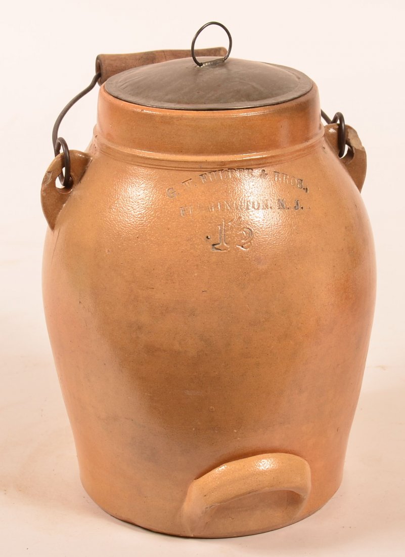 G.W. Fulper & Bros. Flemington, NJ 1-1/2 Gallon: G.W. Fulper & Bros. Flemington, NJ 1-1/2 Gallon Stoneware Pottery Batter Jug. Ovoid form, wire bail handle with wood grip and tin lid. 10-3/4"h. Condition: Good, chips on handle mounts.