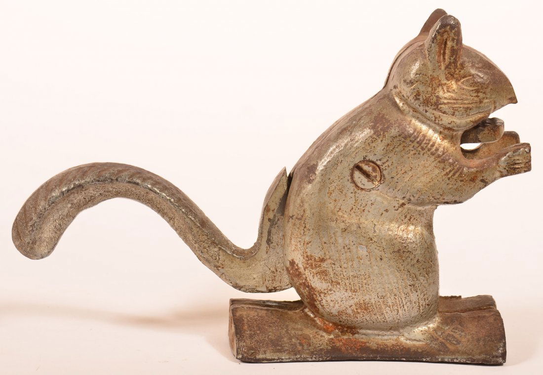 Cast Iron Squirrel Form Nut Cracker.: Cast Iron Squirrel Form Nut Cracker. Painted silver with articulated tail mechanizes jaw to crack nut. 6"h. x 8-1/2"l. Condition: Good, minor rust and pitting.