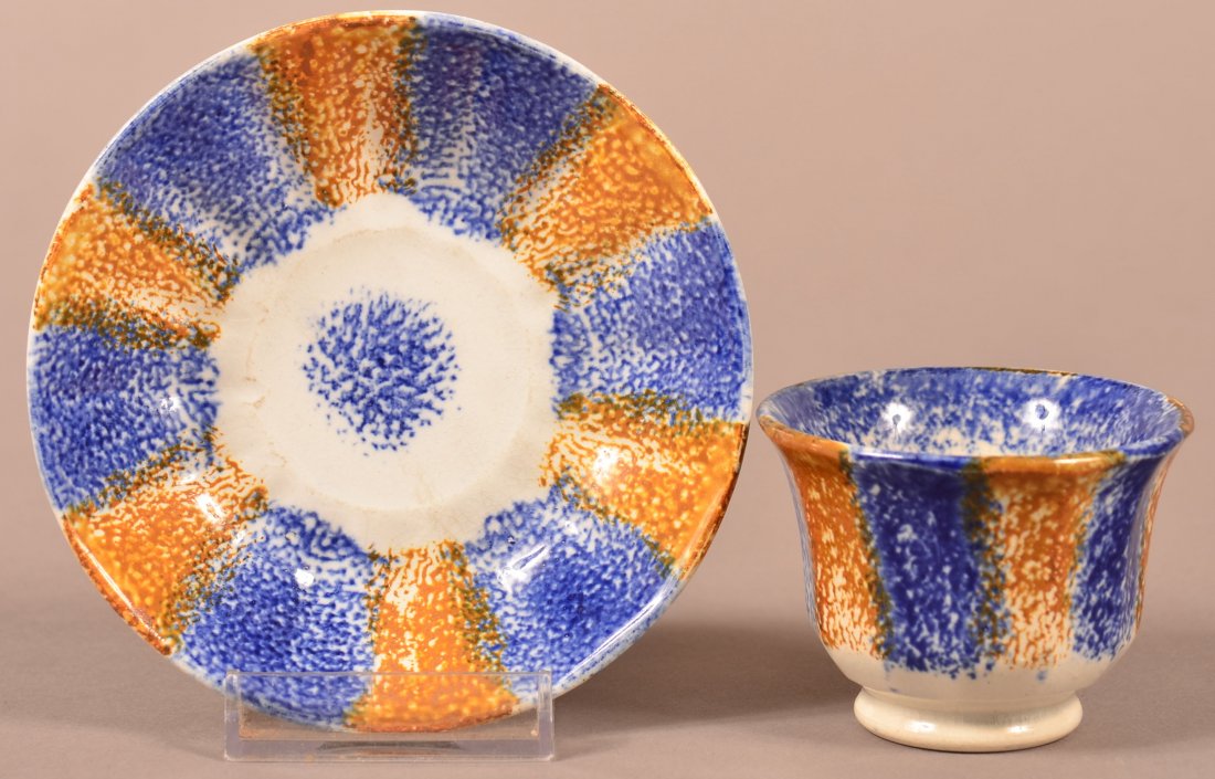 Rainbow Spatter Child's Cup and Saucer.: Blue and Yellow Rainbow Spatter Child's Cup and Saucer. Paneled form with handleless cup and saucer with bull's eye center. Saucer measures 4-3/4" diam. Condition: Cup has tiny flake chip on inside of