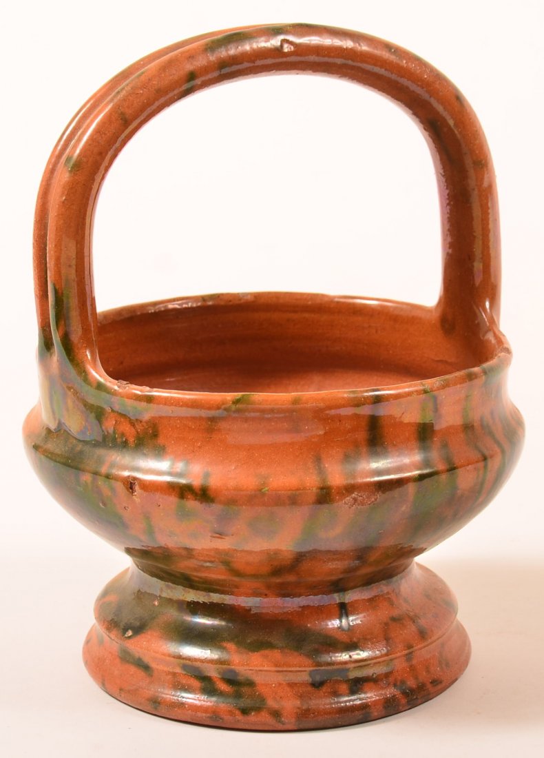 Green and Brown Glazed Redware Basket.: Green and Brown Mottle Glazed Redware Basket attributed to Lebanon Co. PA Circa 1860. Applied ribbed handle urn form base. 9"h. overall. Condition: Good, minor glaze chips.