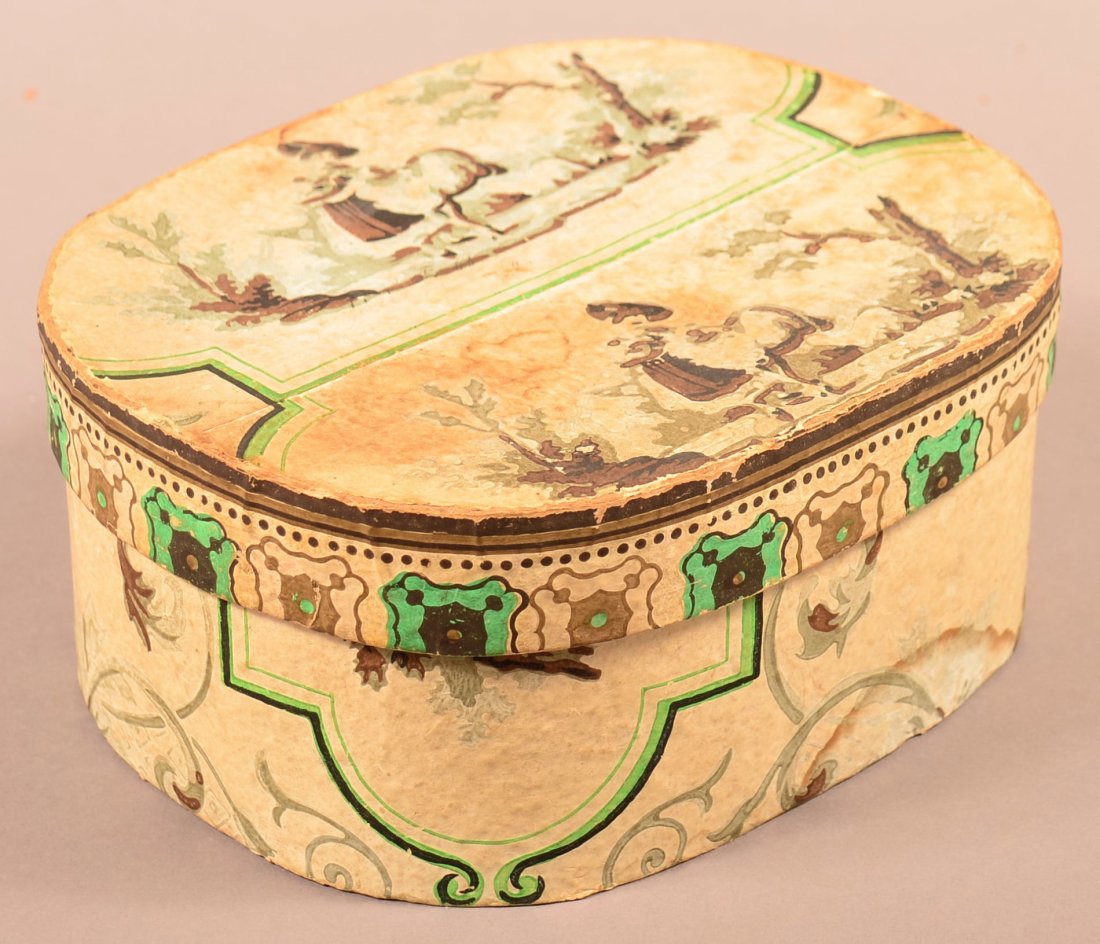 Wallpaper Covered Oval Box.: 19th Century Wallpaper Covered Oval Box. Ivory ground with green, brown and gray decoration, lady with lamb design on lid. 3-3/4"h. x 8-1/4"w. x 6-3/4"d. Condition: Good, minor wear, losses and stains