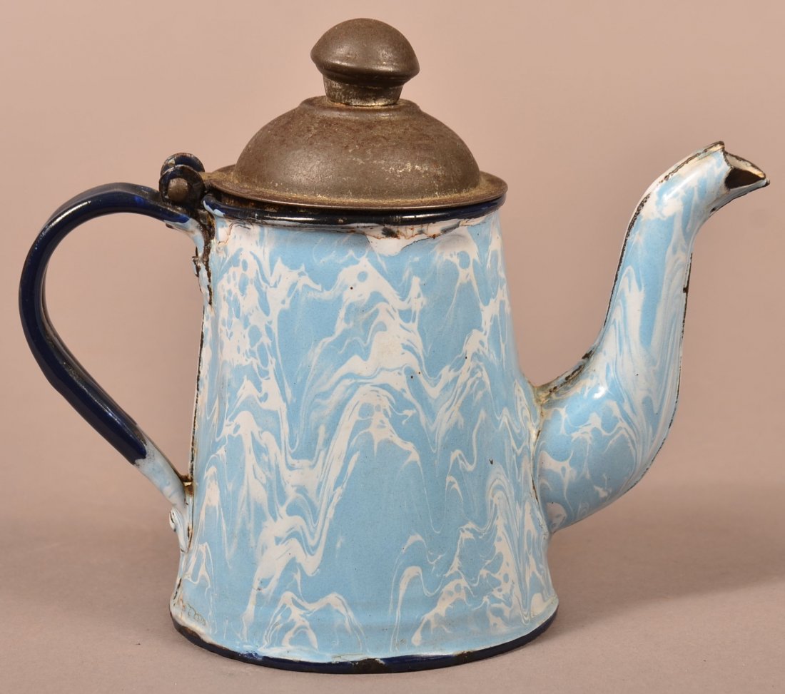 Light Blue Granite Ware Teapot.: Light Blue Granite Ware Teapot. Large swirl, dark blue trim, hinged tin lid. 5-1/2"h. Condition: Good, minor dents and losses.