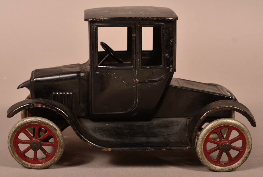 Buddy L Pressed Steel Model T Flivver.: Buddy L Pressed Steel Model T Flivver. Original working steering mechanism. 7"h. x 11"l. Condition: Good, some losses and rust, original partial label on bottom.