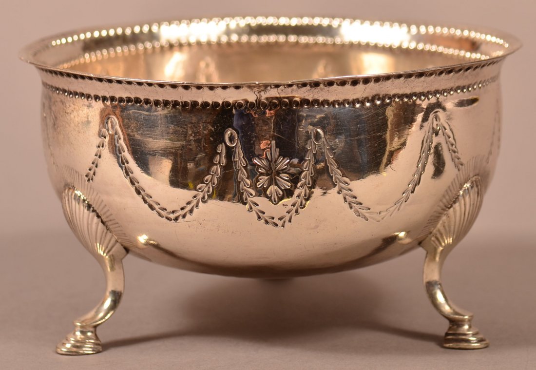Dublin Silver Footed Bowl by Matthew West.: Dublin Ireland Silver Footed Bowl by Matthew West. Date marked 1788, rosette and drape decoration with shell and hoof feet. 5 troy ozs. 3"h. x 5"diam. Condition: Good with 2 small crack repairs on rim