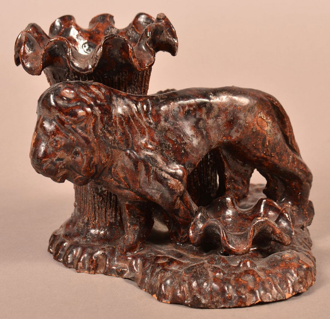 Redware Lion Figural Cigar and Match Holder.: 19th Century Glazed Redware Lion Figural Cigar and Match Holder. Mottled glazed with hand molded features. 5-1/4"h. x 7"w. x 6-3/4"d. Condition: Good with minor chips.