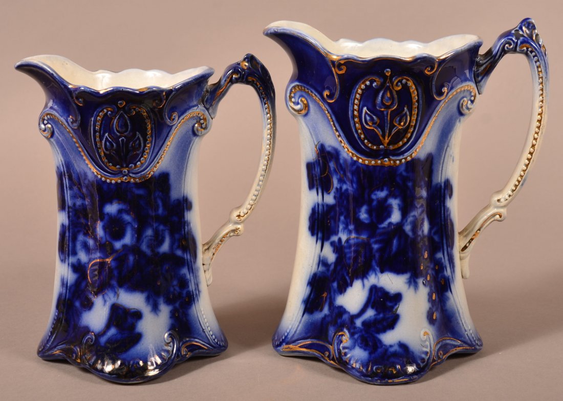 Pair of Flow Blue China Pitchers w Gold Trim: Pair of Matching Flow Blue China Pitchers w Gold Decoration . 9" and 8". Condition: Very good.
