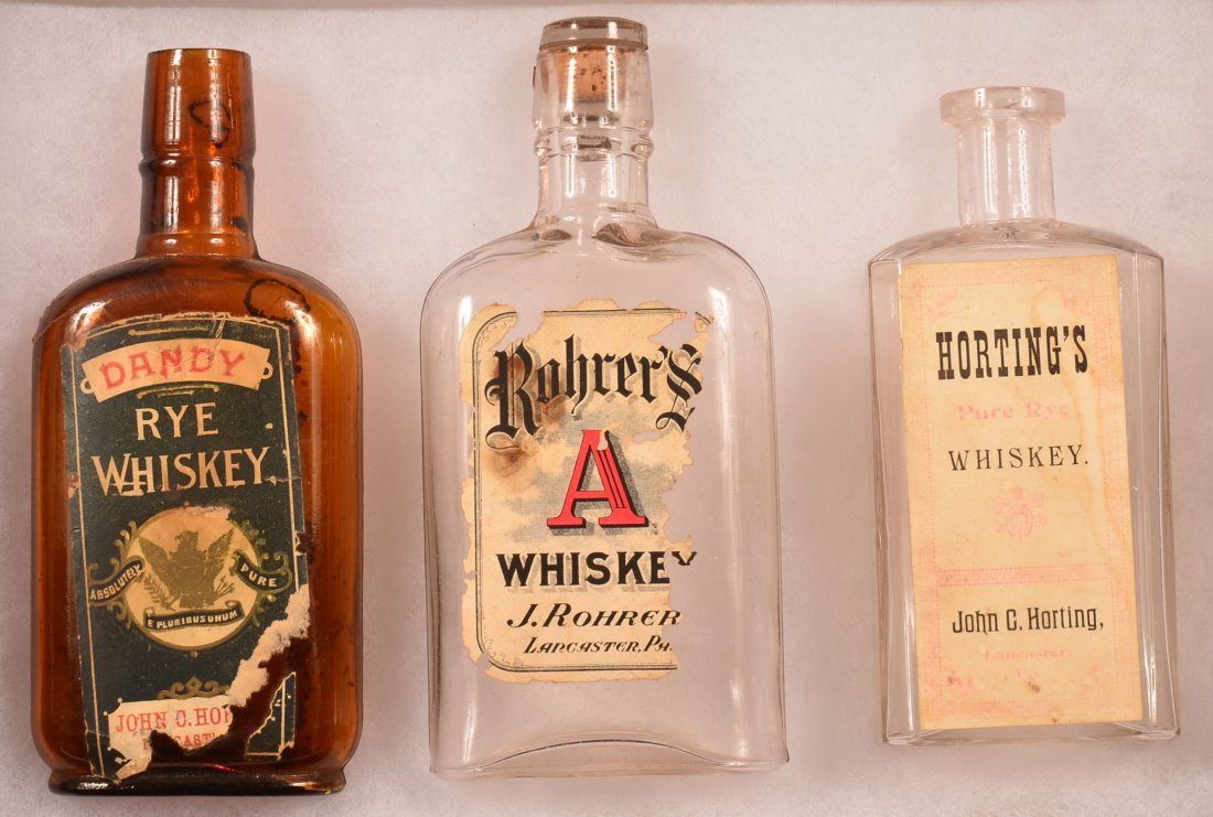 Three Paper Label Whiskey Flasks, Lanc., PA.: Three Paper Label Whiskey Flasks, Lancaster, PA. (1) 6 1/2 " Amber "Dandy Rye Whiskey" by John C. Horting; (1) 6 1/2 " Clear Rohrer's A. Whiskey, By J. Rohrer, and (1) 5 1/2" Clear"Horting's Pure Rye