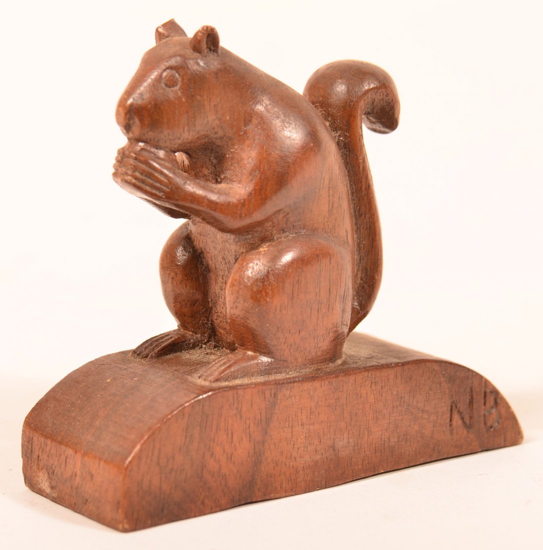 Small Walnut Carving of a Squirrel Eating a Nut.: Small Walnut Carving of a Squirrel Eating a Nut. Signed N B on arched base. 3-1/4"h. Condition: Good with tiny chips on ears.