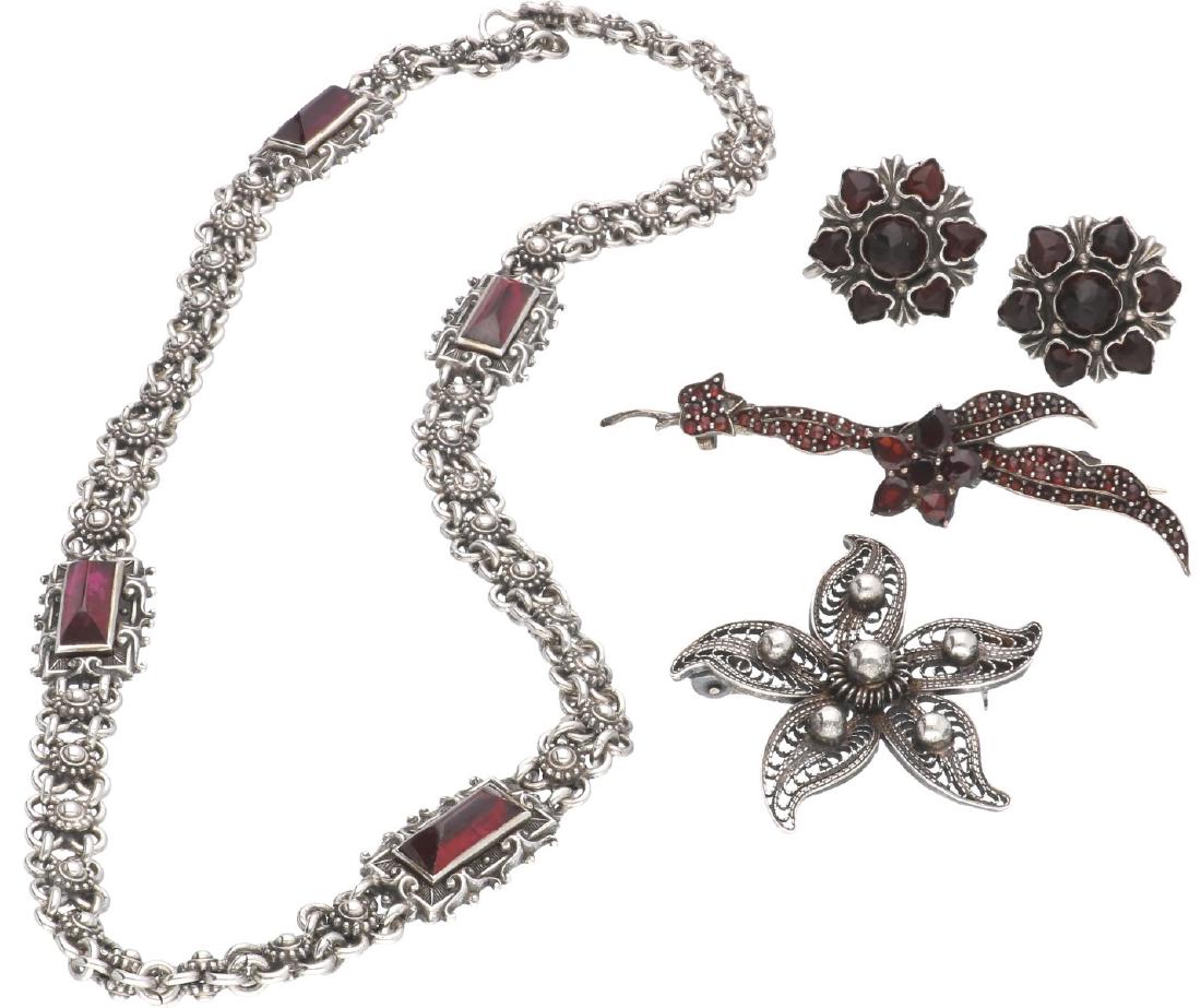 Lot silver, with granate - 835/1000.: Choker, earrings, 2 brooches. Various dimensions. Weight: 49.9 grams.