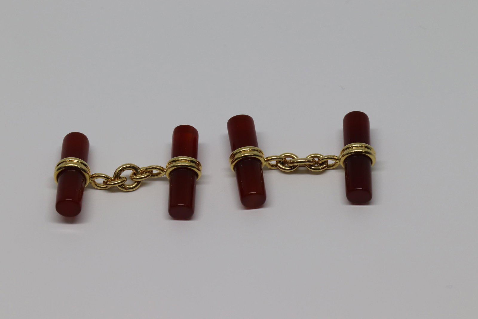 18Kt Sulka Men's Cufflinks: A Vintage 18kt Yellow Gold Sulka Cufflinks. Four translucent amber-color cylinders, composed of carnelian, are harnessed and chained in 18 karat yellow gold by the renowned purveyors of gentlemen's sh