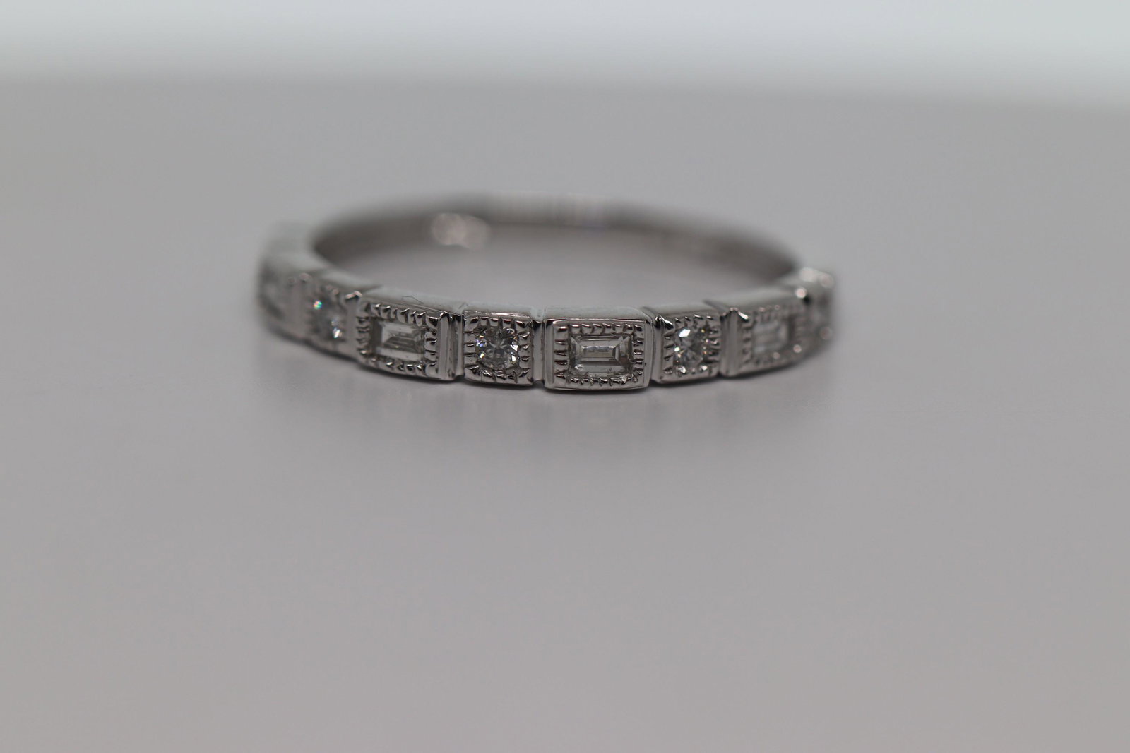 Bezel Set Baguette & Round Diamond, White Gold Milgrain: Bezel Set Baguette & Round Diamond 10k Gold Milgrain Stackable Band Ring. Metal:10k White Gold Ring Size:7 Gender:Womens Resizable:Yes Width:2.7 mm Carat Total Weight:0.13 Condition:new TOTAL DIAMOND 