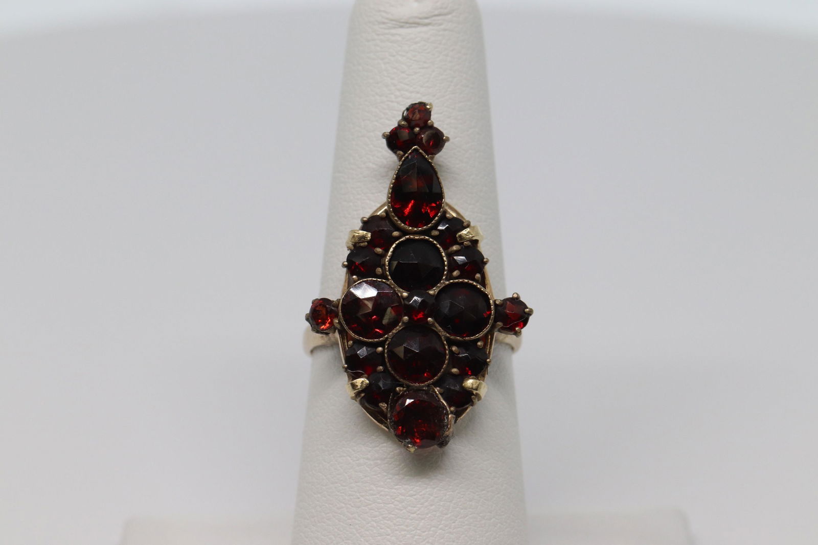 Art Deco 14Kt Ladies Ring: A gorgeous 14kt Yellow Gold Art Deco Garnet ring. This ring has a total of 21 Red Garnet Stones on the center of the ring. The stones are set on prong and bezel settings. The ring size is 7.00. Total